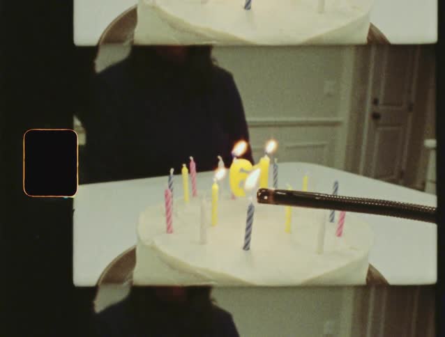 Vintage home movie footage of lighting the number 61 candles on a birthday cake
