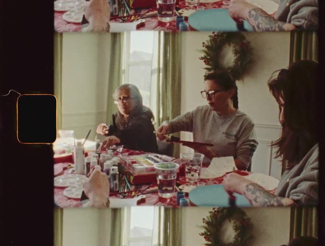 A family enjoys a quiet holiday afternoon together painting arts and crafts, captured in a vintage film aesthetic