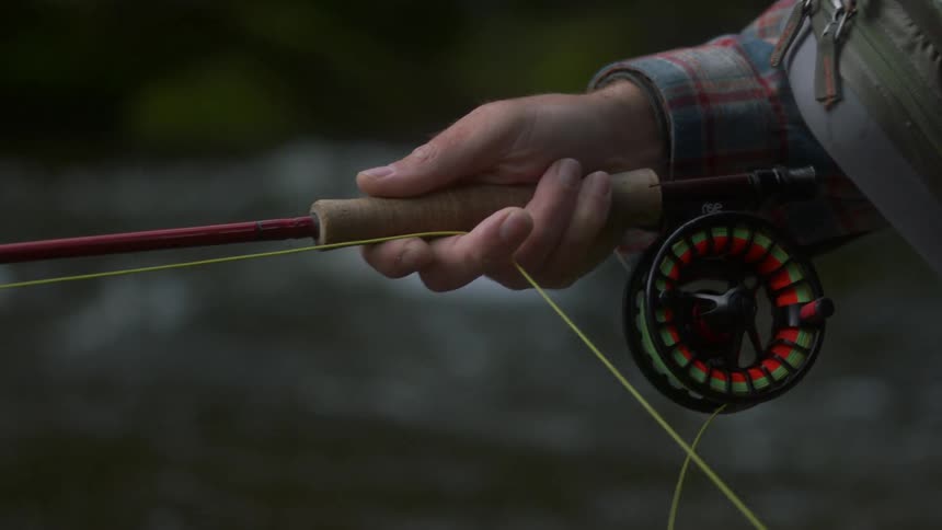 A fisherman pulls in his fishing line