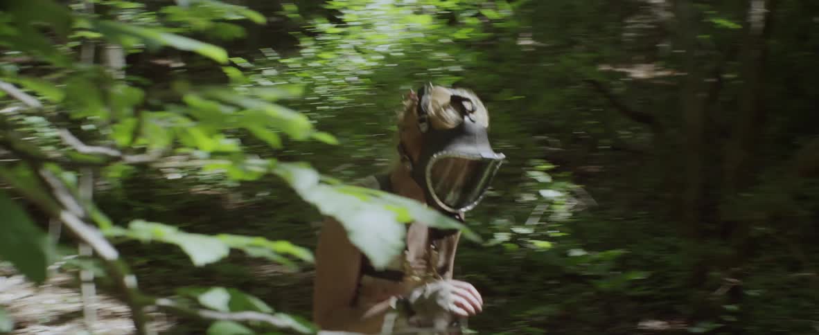 Person wearing a helmet walking through the woods