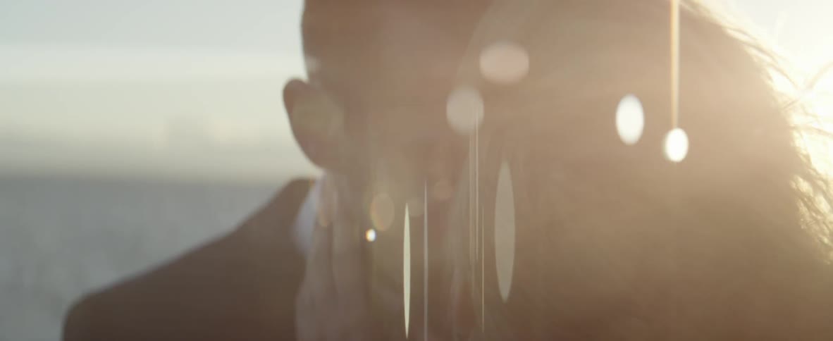 A man and woman are kissing as the sun sets