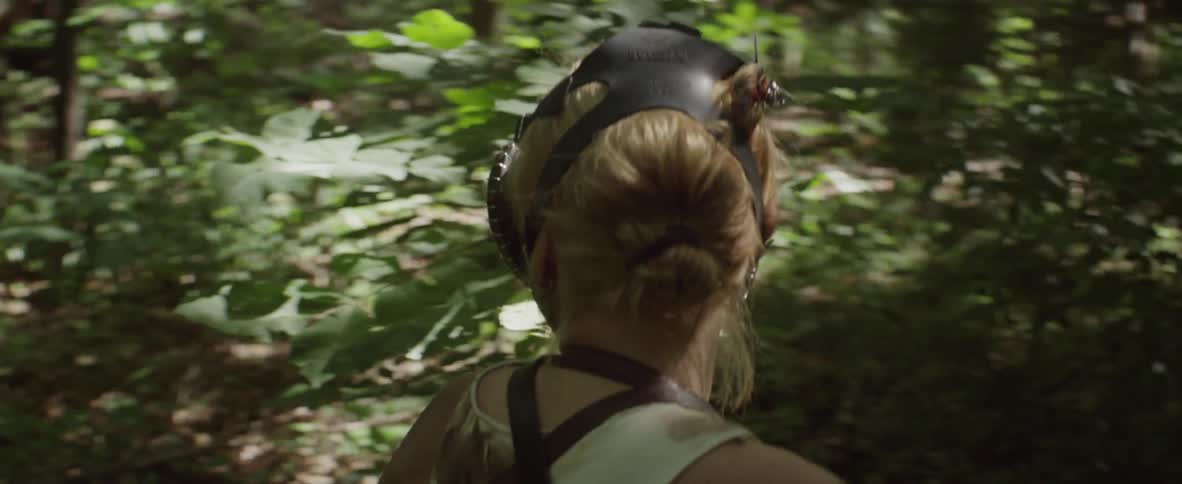 A woman with a gas mask hikes in the woods