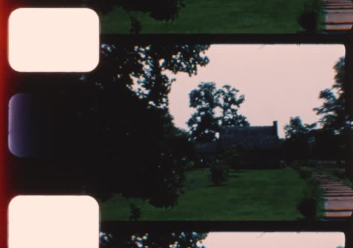 A vintage 8mm film captures directional signs and a view of the original cabin at The Hermitage historic site