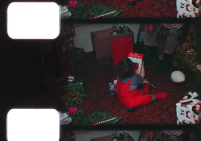 Vintage 8mm footage captures the joy of a family opening presents together on Christmas morning in the 1970s