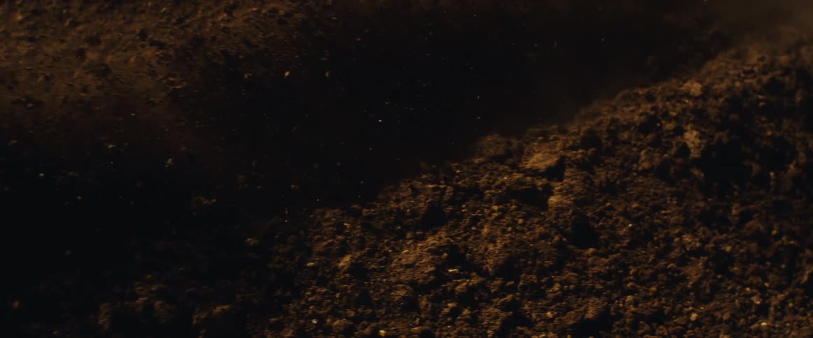 A close-up slow motion shot shows a motocross tire digging into the ground and kicking up dirt