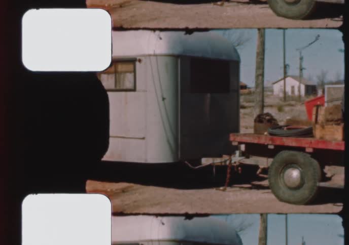 Archival footage shows a vintage red construction truck from Odessa, Texas, pulling a silver travel trailer