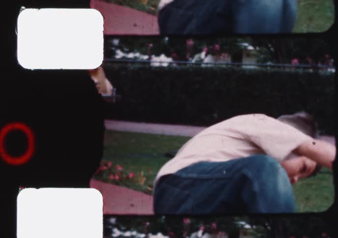 An authentic 8mm home movie captures a young boy playing in the front yard during the 1950s