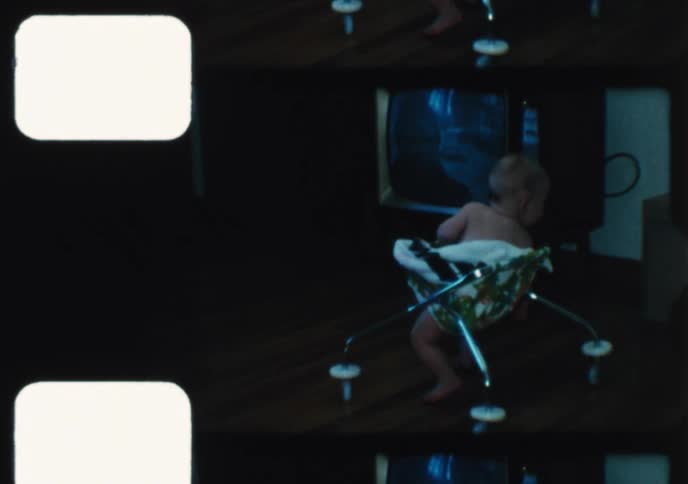 Vintage 1960s home movie footage shows a cute baby in a walker watching the Apollo moon landing on television