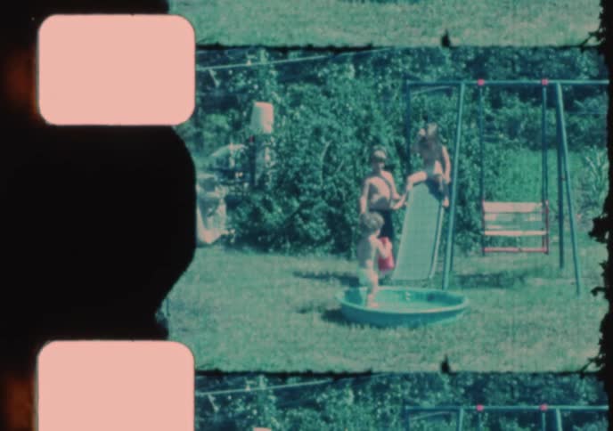 Damaged and faded vintage film shows children playing in a backyard with a wading pool and slide