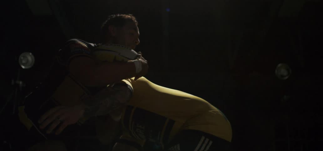 Two rugby players collide in a powerful slow-motion tackle under a dramatic spotlight