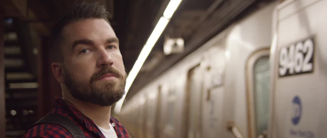 Man standing near a moving subway