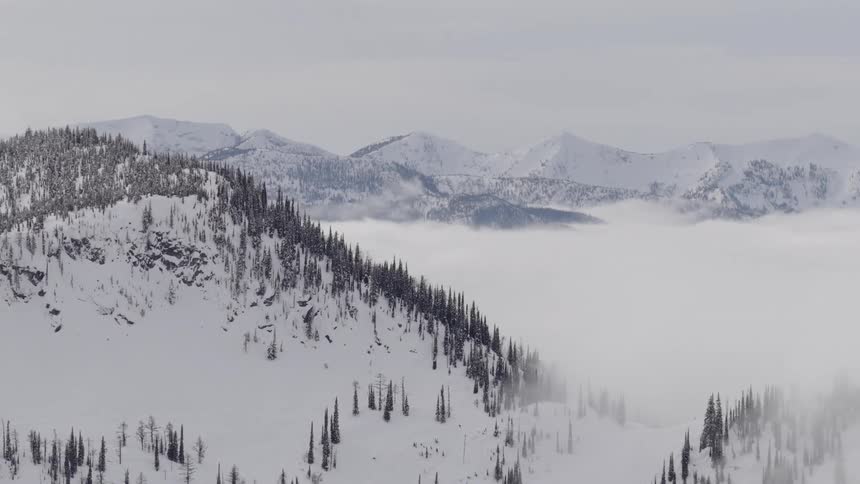 A breathtaking aerial view of a majestic snow-covered mountain range rising above a sea of clouds