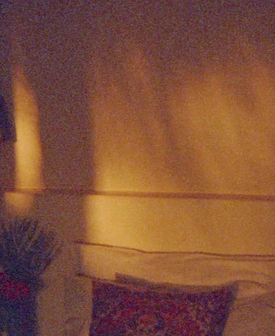 Abstract time-lapse of warm golden sunlight casting moving shadows across a grainy bedroom wall