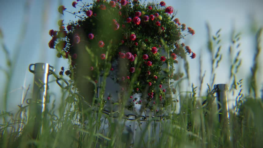 An abstract looped animation of a chained monument reclaimed by nature, with vibrant pink flowers blooming amidst swaying tall grass