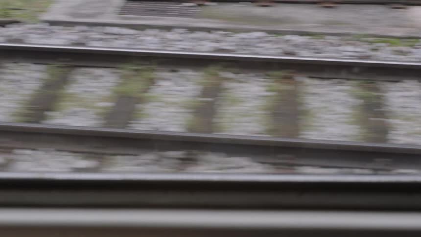 Blurry close-up of railway tracks filmed from a moving train