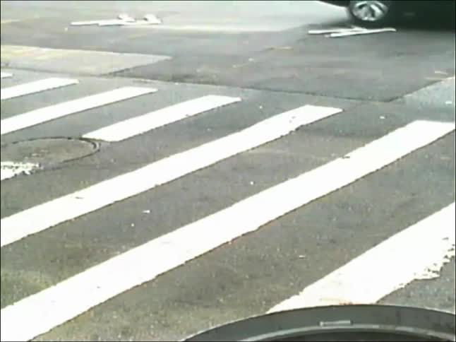 A vintage, high-angle view of people crossing a city street at a crosswalk