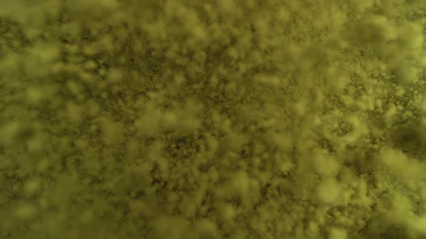 A vibrant yellow-green powder falls and settles in super slow motion against a dark background