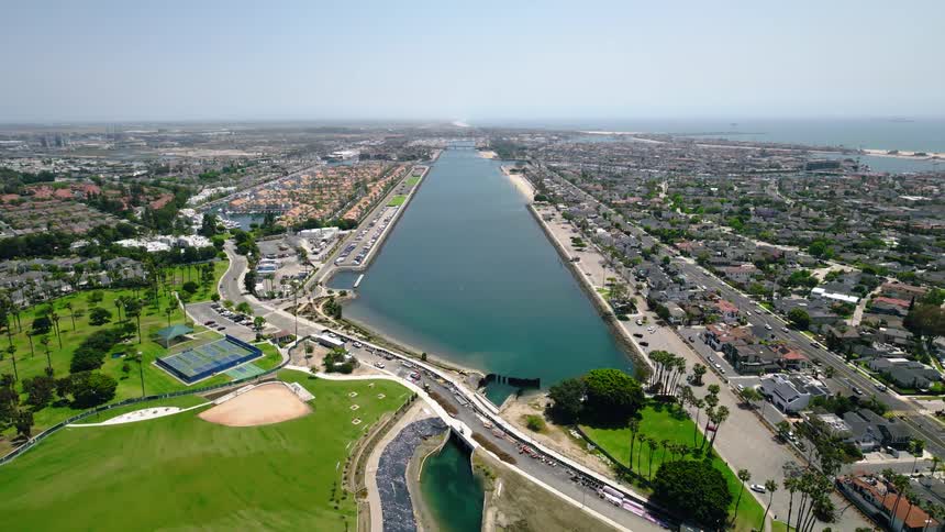 Stationary aerial drone view overlooking the Long Beach Marine Stadium and Alamitos Bay in California, with the city and Pacific Ocean in the distance