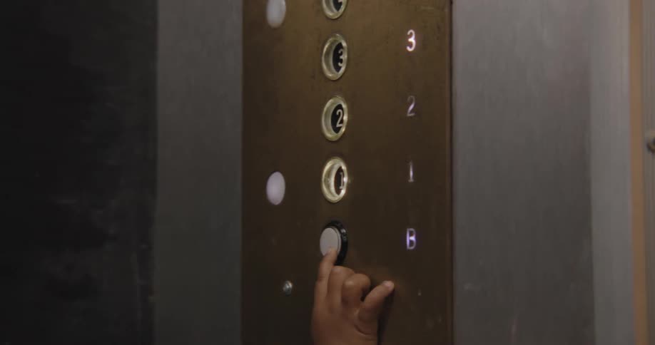 A curious child playfully presses the glowing buttons on a vintage elevator control panel