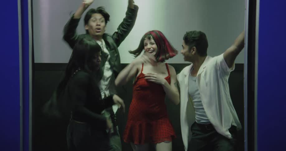 Energetic friends dance and party inside an elevator as the doors open before running out together
