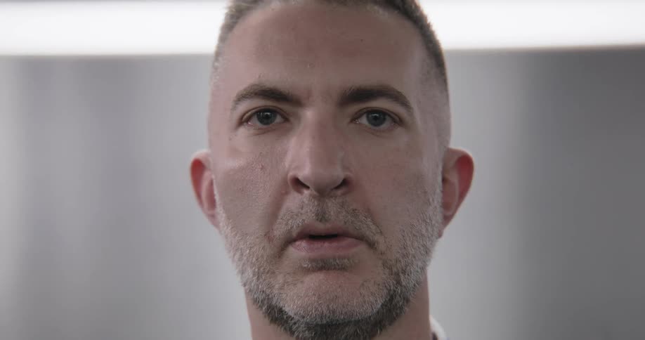 A close-up of a man's face as he processes information with expressions of shock, annoyance, and disbelief