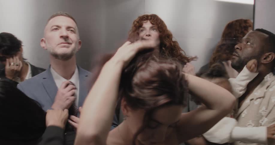 Strangers from all walks of life share a moment of silent contemplation and discomfort in a full elevator