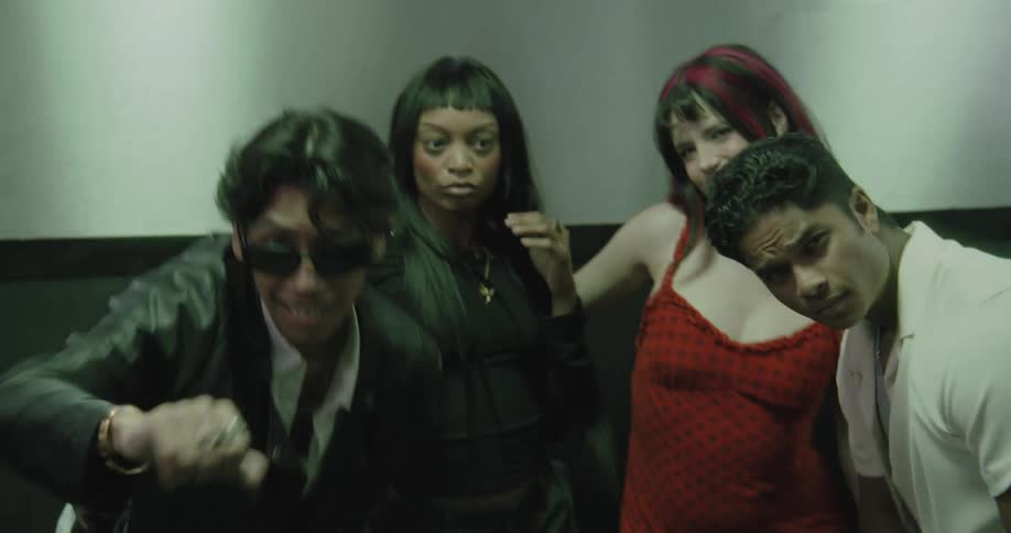 A group of diverse and stylish young adults dance and pose for the camera in an elevator