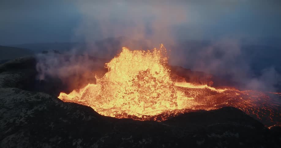 Slow motion footage reveals the raw power of a volcano as molten lava explodes from the earth's crust under a dark sky