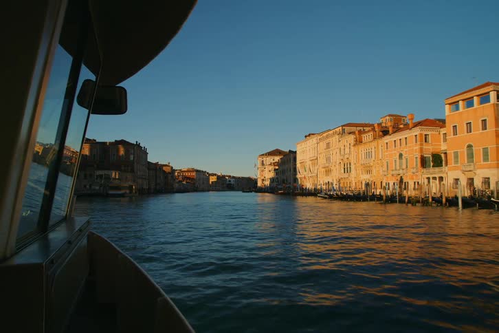 A serene point-of-view from a water taxi on the Grand Canal in Venice during a beautiful sunrise