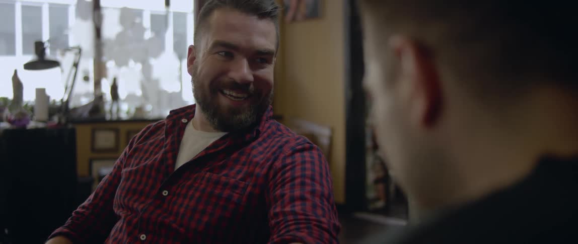 Two men laughing and talking in a cafe