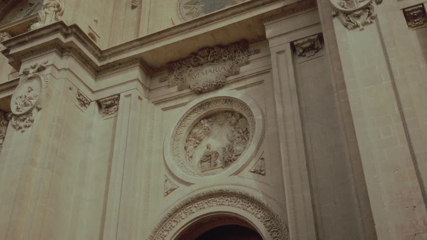 A static low-angle shot of the ornate stone carvings and reliefs on the facade of a historic European cathedral