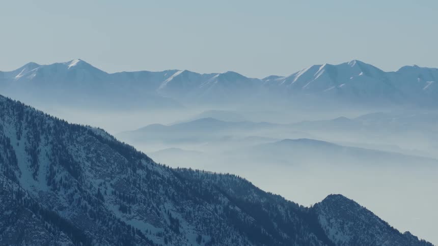 A breathtaking landscape view of snow-capped mountain ranges rising above a sea of thick fog