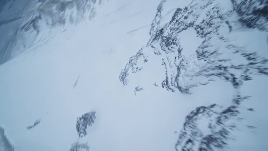 A fast-paced aerial view soaring along the icy ridges of a vast, wintery mountain landscape