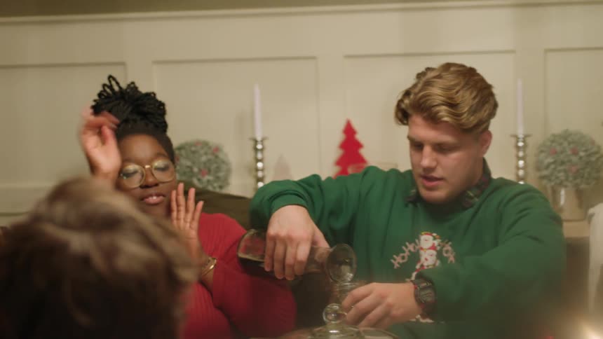 A group of people pour wine and eats at a large table