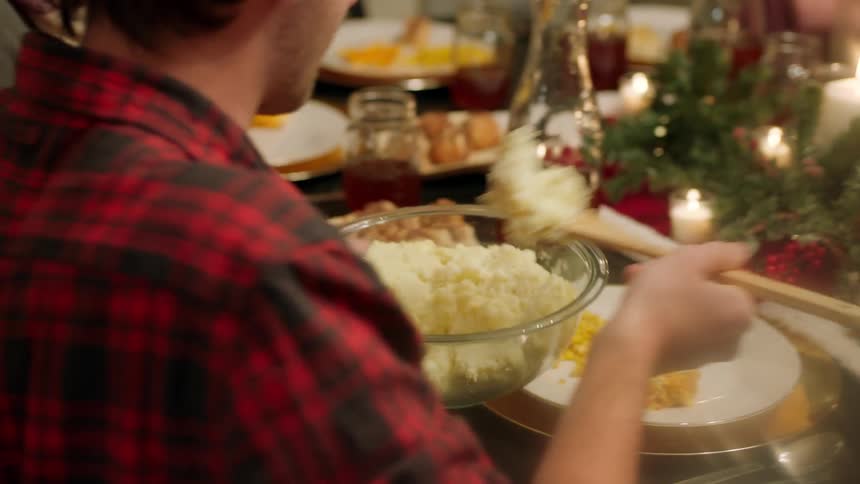 A group of people around a table talking and getting food