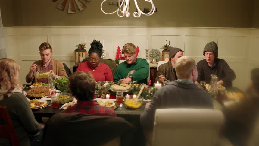A family eats around a large table at christmas time