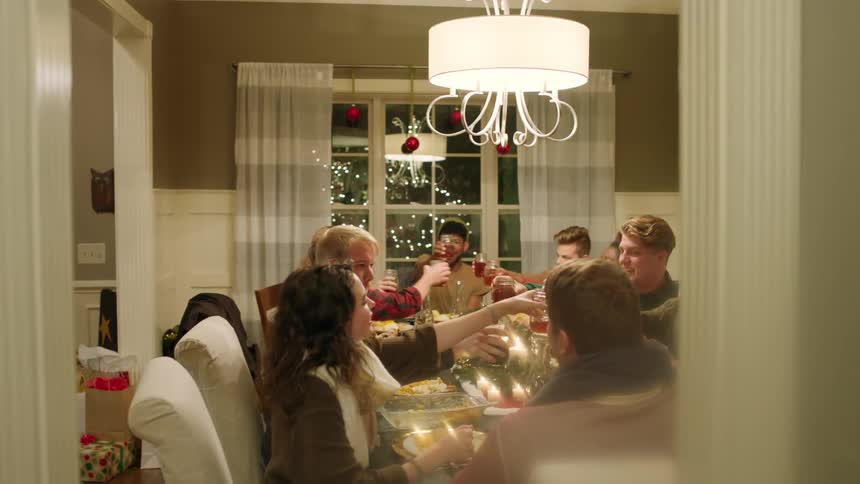 A group celebrates around the dinner table at christmastime