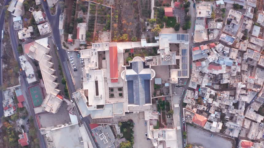 A static top-down aerial shot reveals the cross-shaped roof of the Basilica of the Annunciation in the historic city of Nazareth, Israel