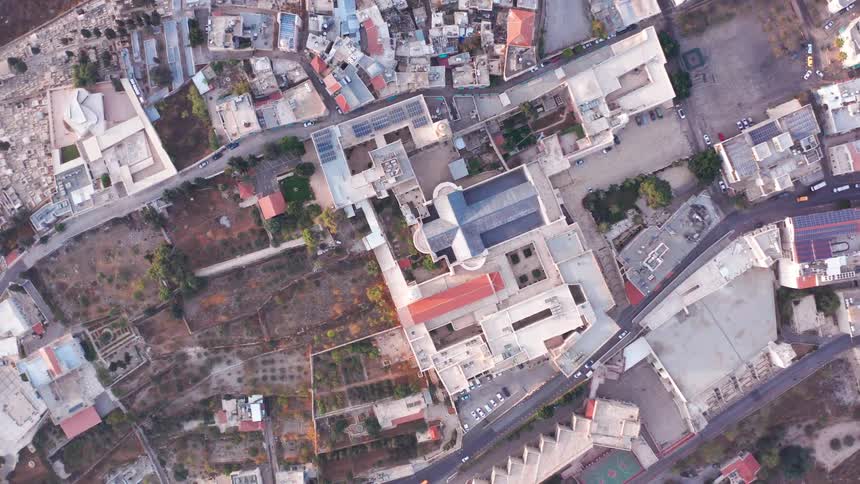 A stunning top-down aerial view slowly rises above the Basilica of the Annunciation in the heart of Nazareth, Israel