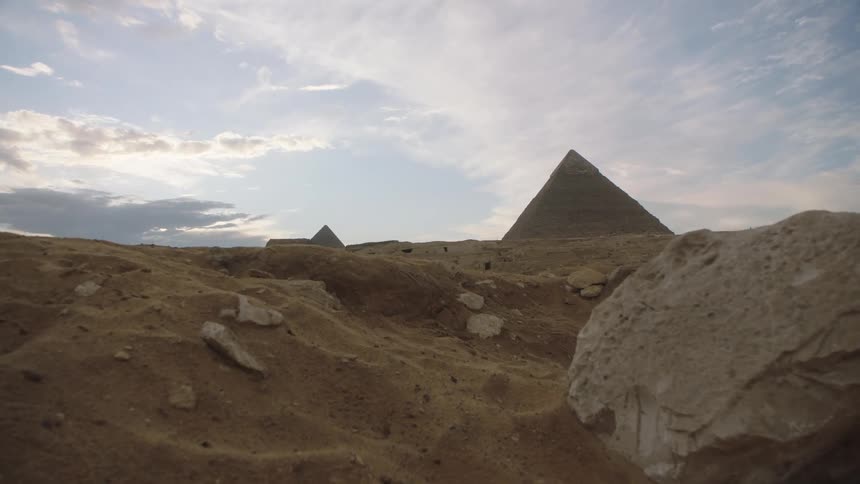 The Great Pyramids of Giza are revealed in a slow dolly shot across the sandy desert landscape