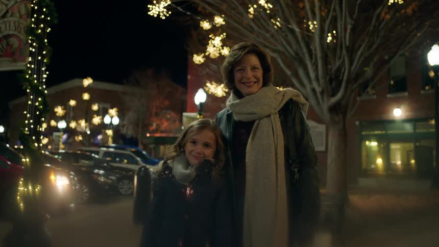 A woman poses for a picture with a child at night