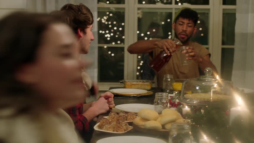 A group eats at a dinner table at christmastime