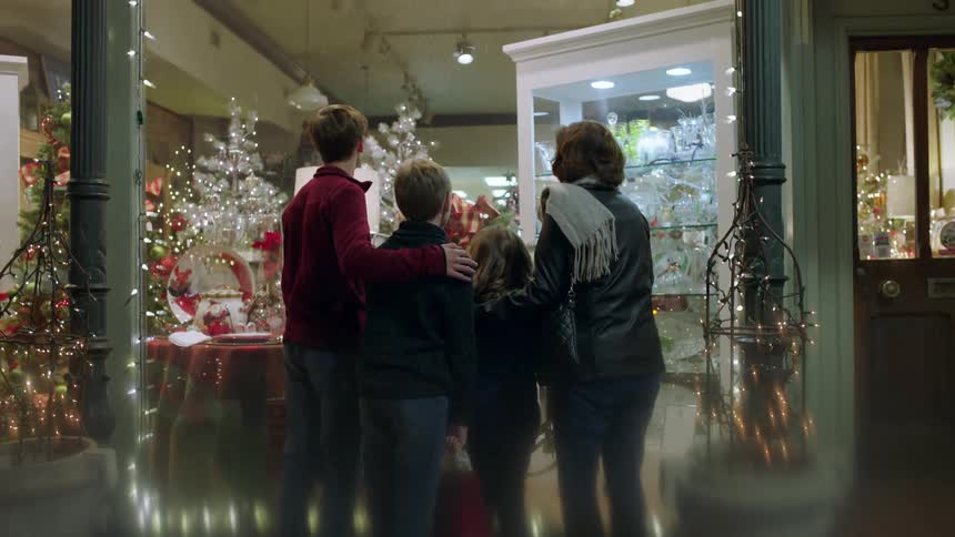 A family window shops at night