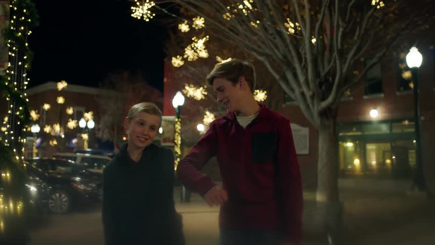 Two boys pose for a picture at night