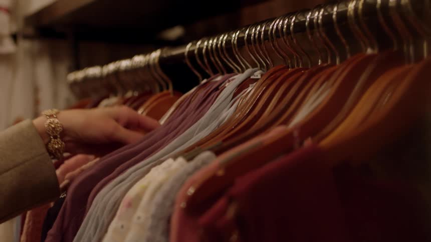 Woman looks at a shirt in a shop