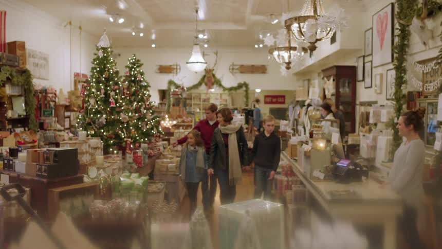 People walking through a store  full of christmas decorations