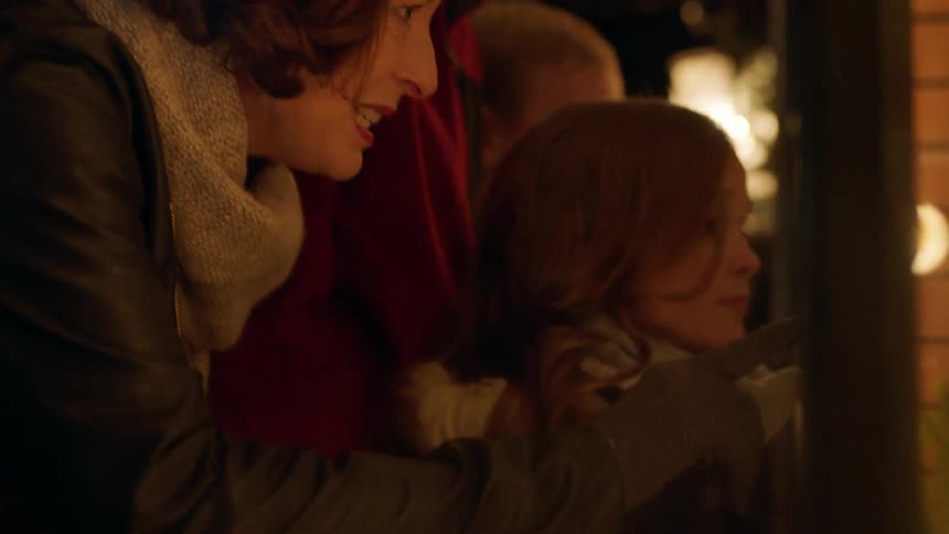 Woman and children look through the window of a store