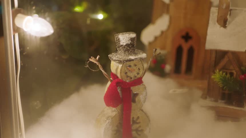 A snowman ornament is behind the glass