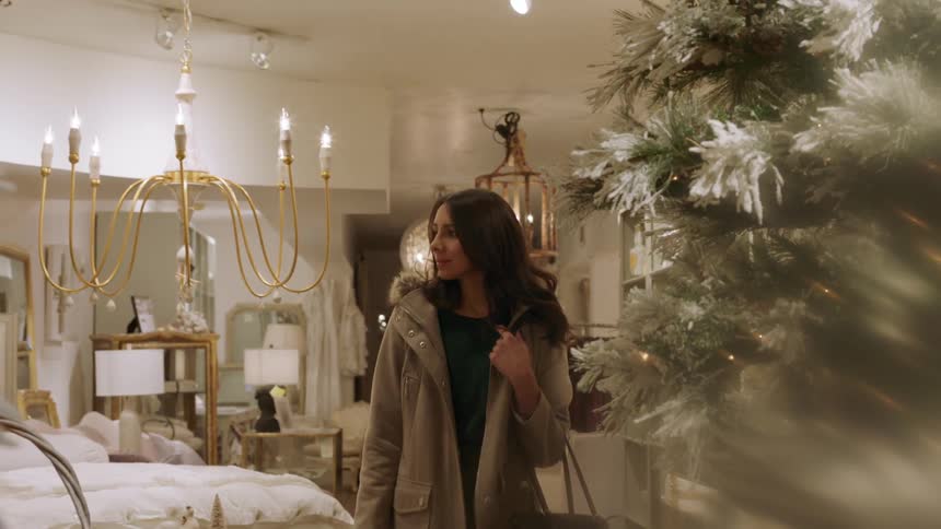 A woman is walking in a shop carrying a bag