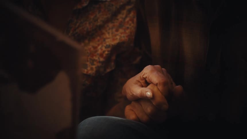 An intimate close-up shot of an elderly couple holding hands, symbolizing enduring love and support